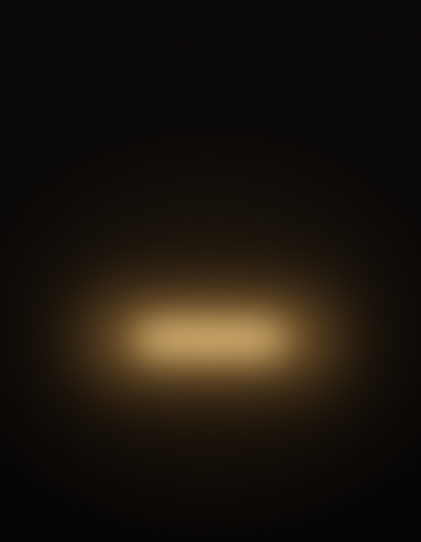 Warm amber light inside an empty hyperbaric chamber, held in darkness.